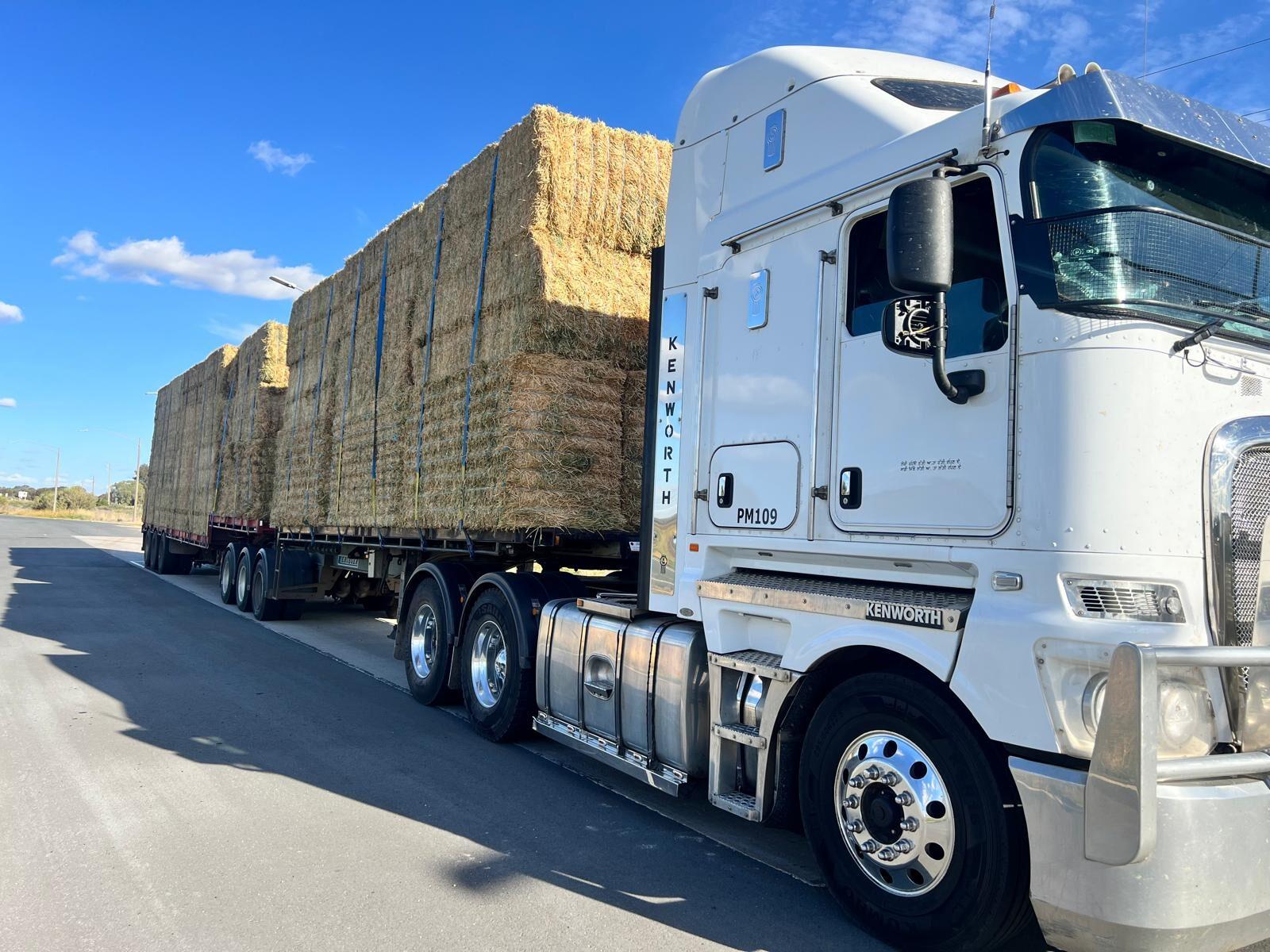 A Farm Direct truck loaded with big square bales, ready to deliver